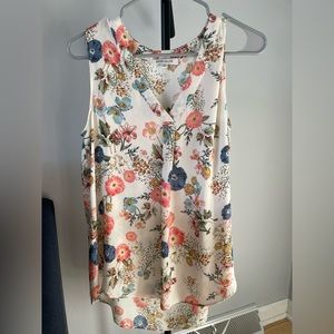White sleeveless v-neck blouse with pink and blue floral